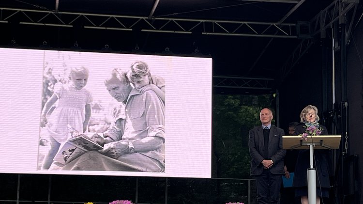 Eine Frau und ein Mann auf der Bühne. Die Frau schpricht. Im Hintergrund ein Kinderfoto der beiden mit ihrem Großvater Bernard Law Montgomery